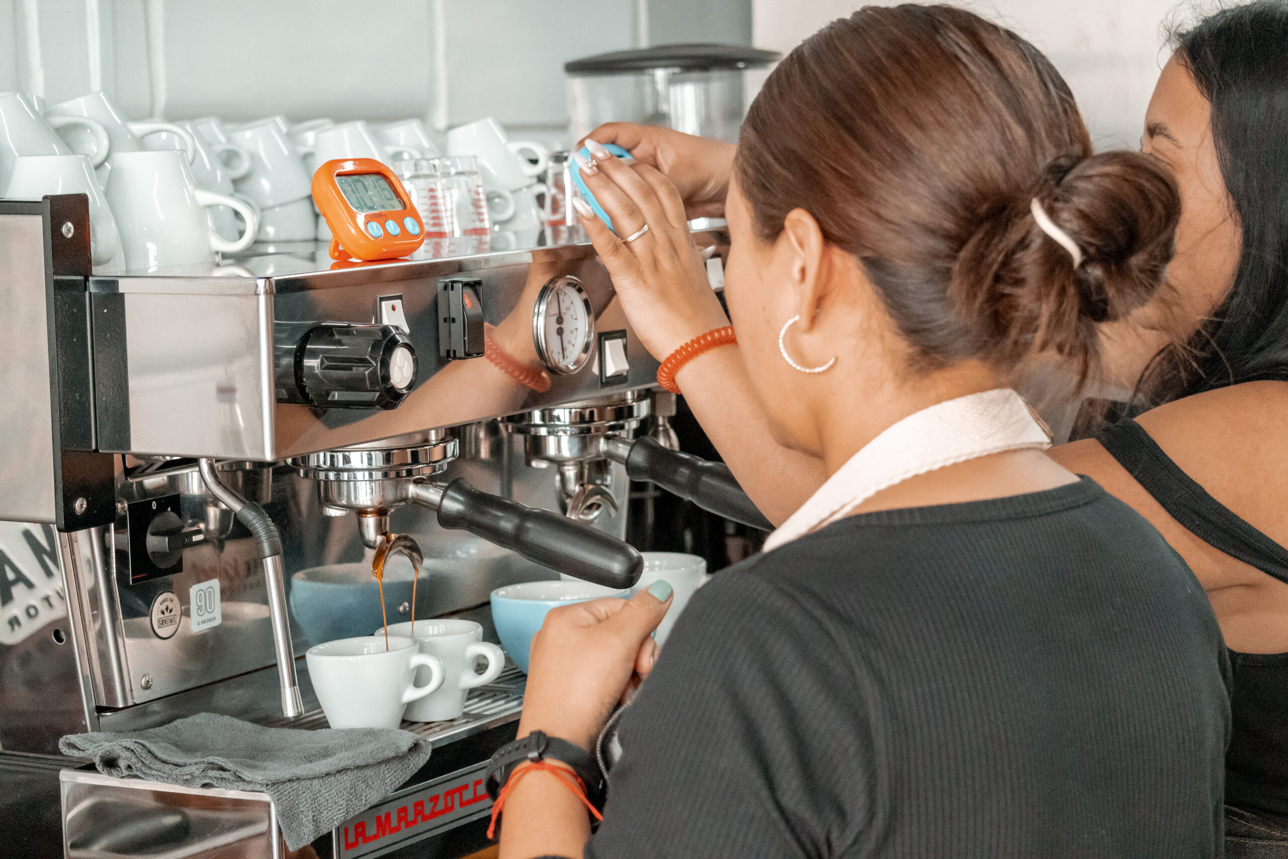 Barista trainee practicing espresso extraction during hands-on coffee training