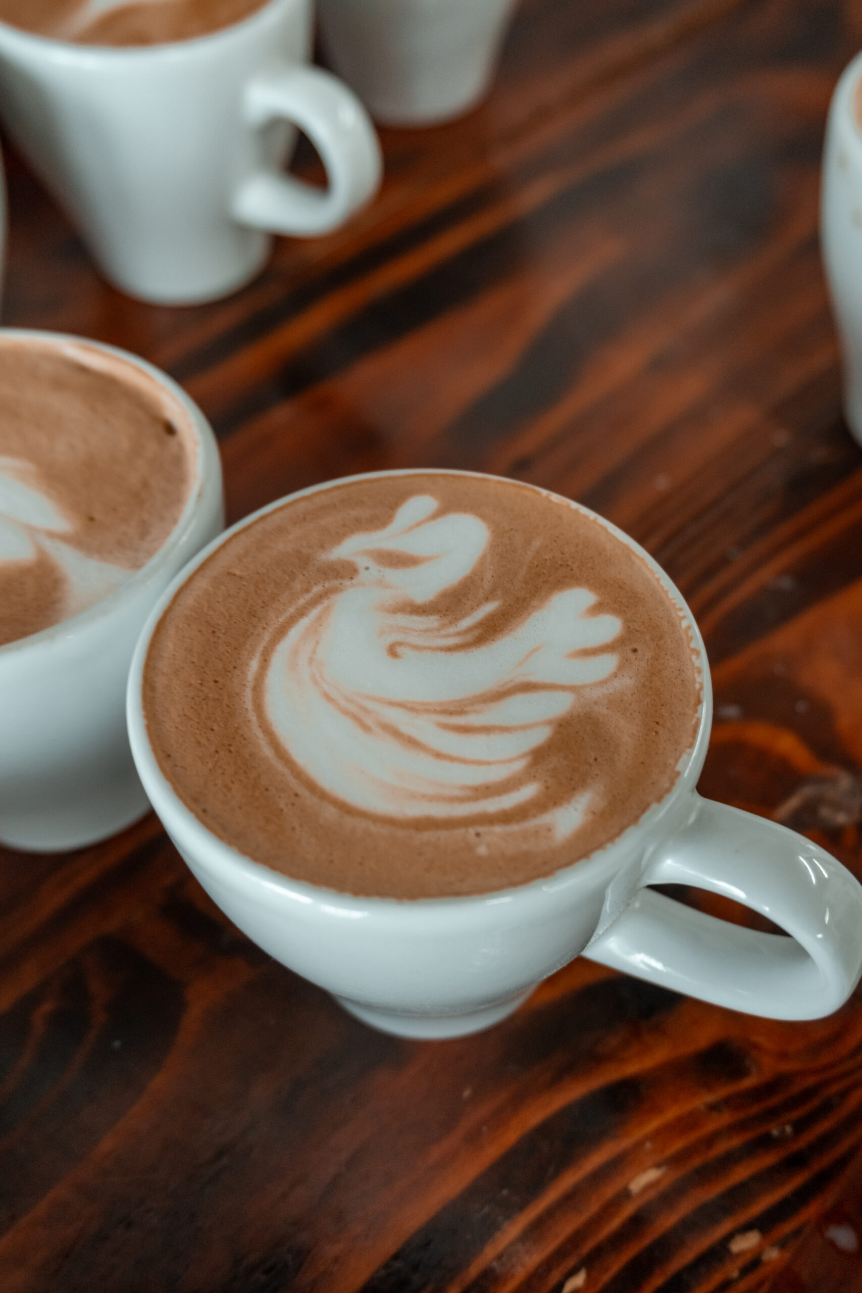 Student pouring latte art under one-on-one guidance in a Miami coffee training classroom